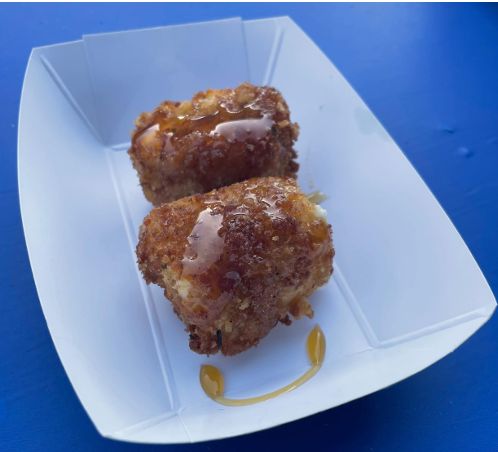 Fried feta bites in a paper tray with honey